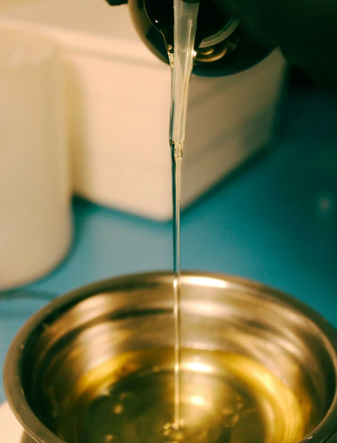 a person pouring water into a metal bowl
